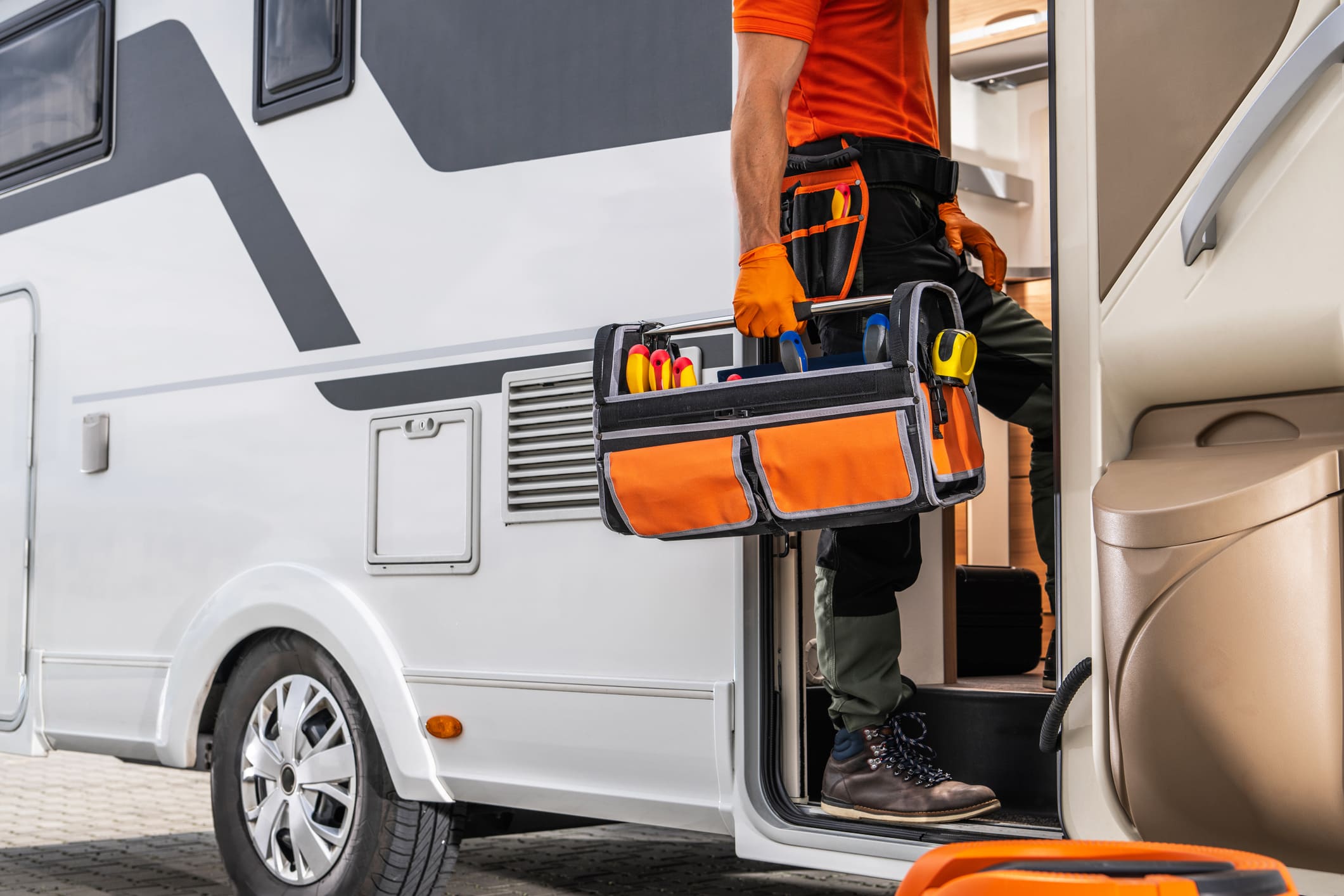 Servicetechniker mit Werkzeugkoffer am Wohnmobil